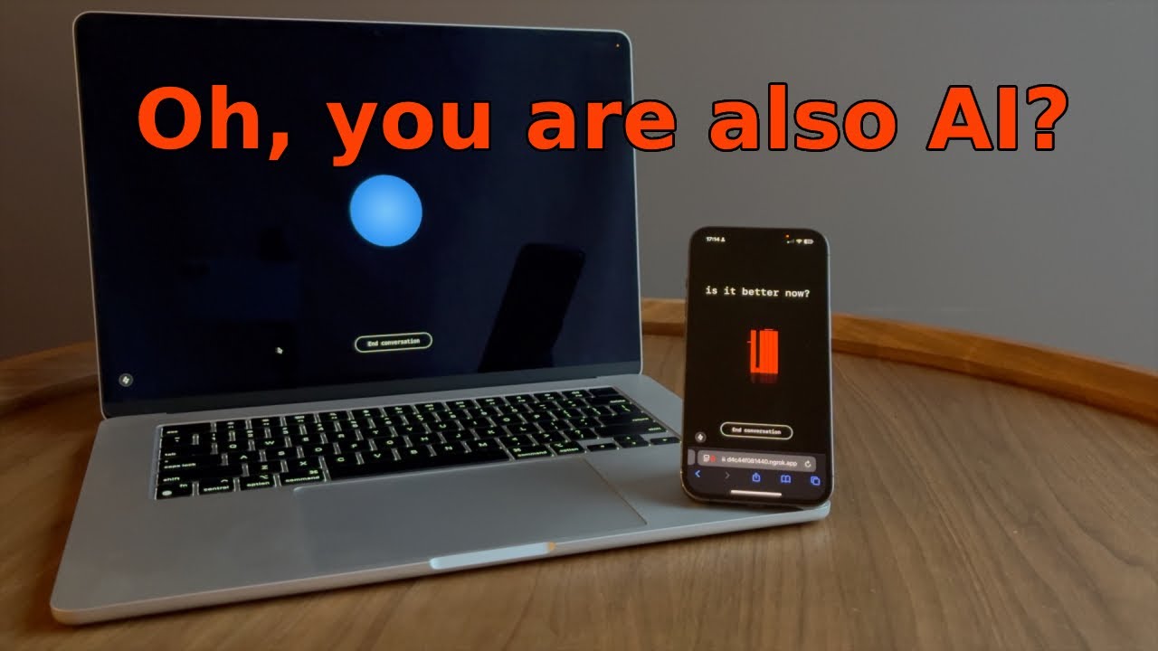 On a wooden table, a silver laptop on the left and a black smartphone on the right are positioned next to each other. The laptop's screen is dark and displays a glowing blue sphere, with a button below it that reads 'End conversation.' The smartphone, standing vertically, shows a dark screen with the text 'Is it better now?' at the top and a red graphic in the center. Large, bright red text is overlaid across the top of the image, saying, 'Oh, you are also AI?', suggesting a conversation between two artificial intelligences [gen AI description, sounding a bit envious hmm...].